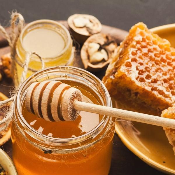 Various types of honey on wooden platter, closeup