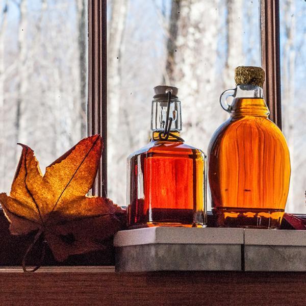 Maple syrup in old bottles at window